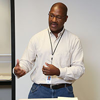 An image of a man speaking at a corporate-sponsored event.