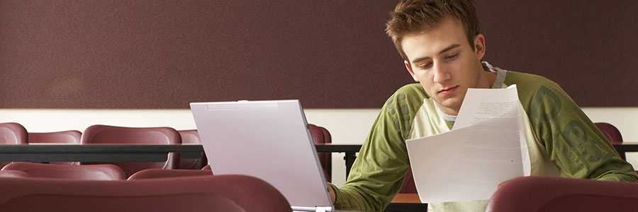 A banner of an image of a young man studying on his laptop.