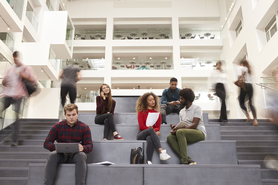 An image of a group of students sitting on the stairs and chatting.