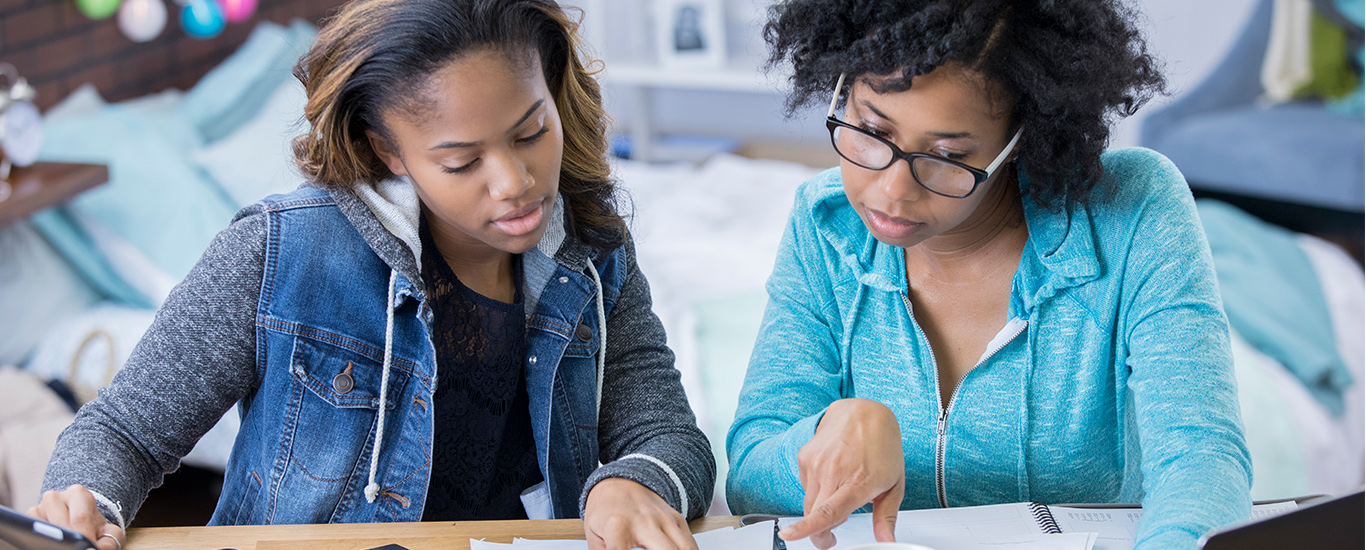 An image of a couple of young women looking over paperwork.