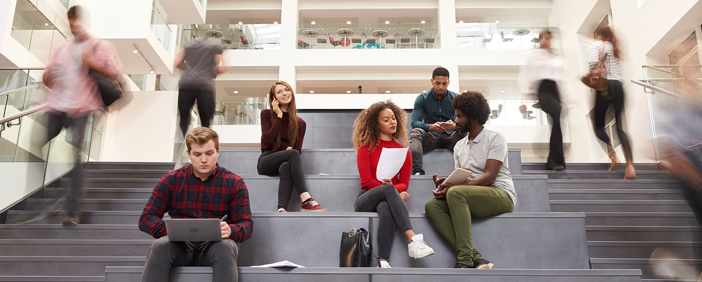 An image of a group of students sitting on the stairs and chatting.
