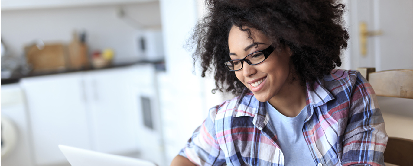 An image of a young woman working on her laptop.