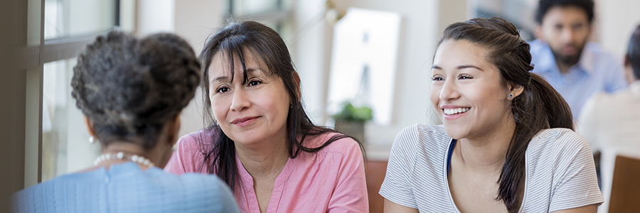 An image of a mother and daughter meeting with a school counselor.