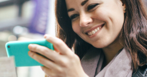 An image of a young woman looking at her cellphone.