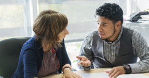 An image of a young man meeting with his professor.