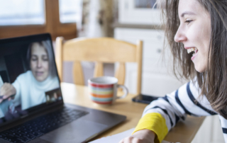 An image of a young woman watching a webinar on her laptop.