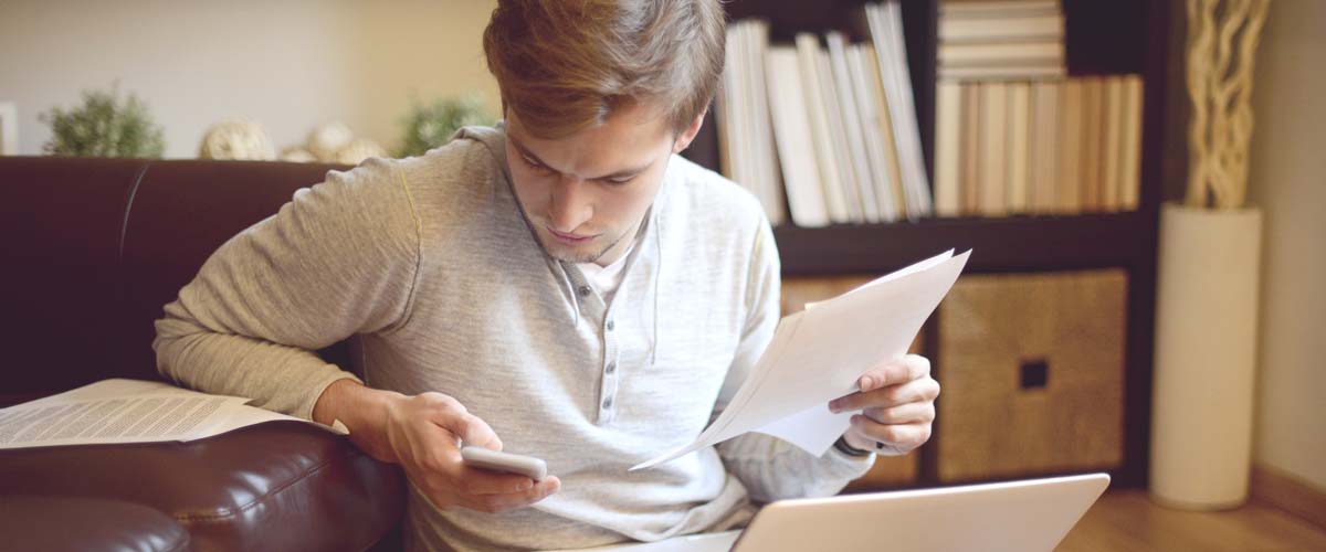 An image of a young man reviewing paperwork.